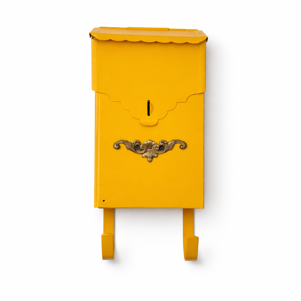 Yellow mailbox with decorative emblem on a white background