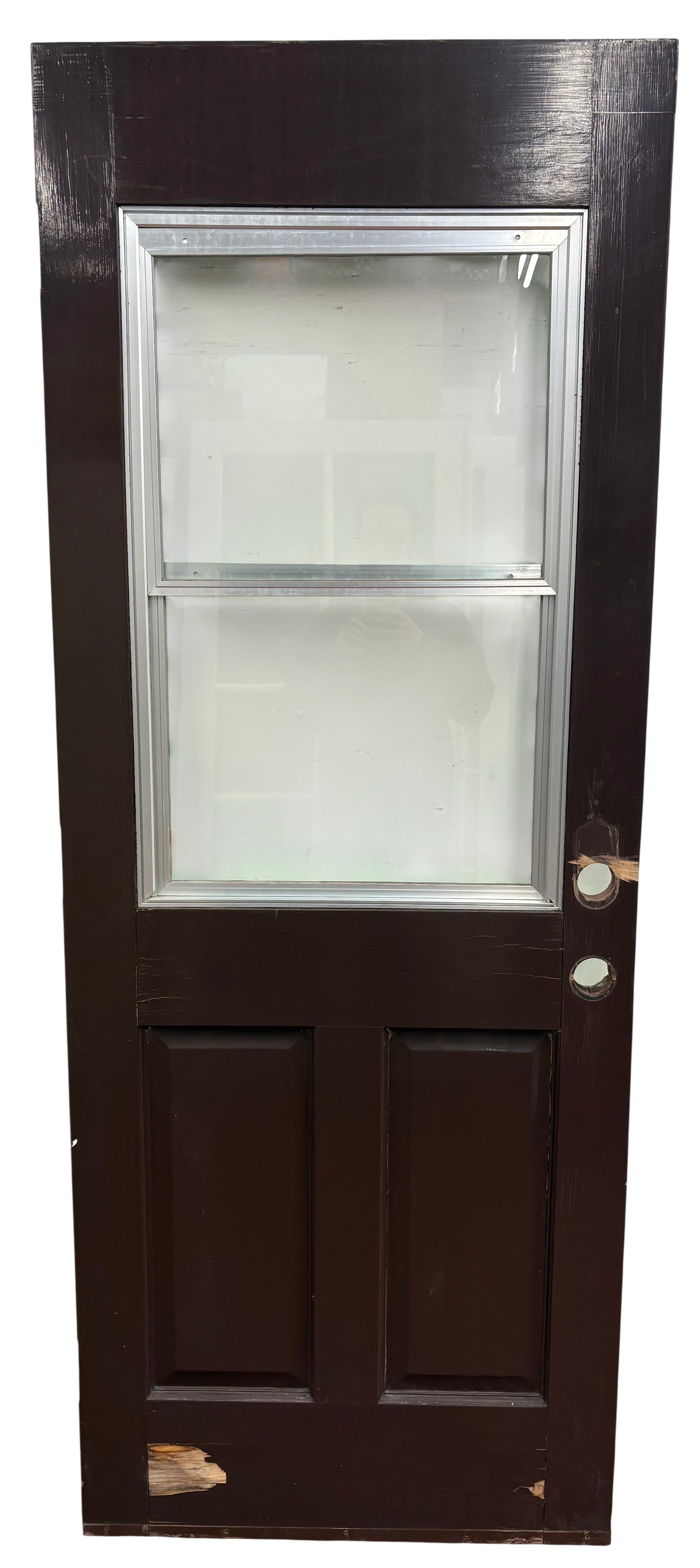 Dark wooden door with glass panels on a white wall