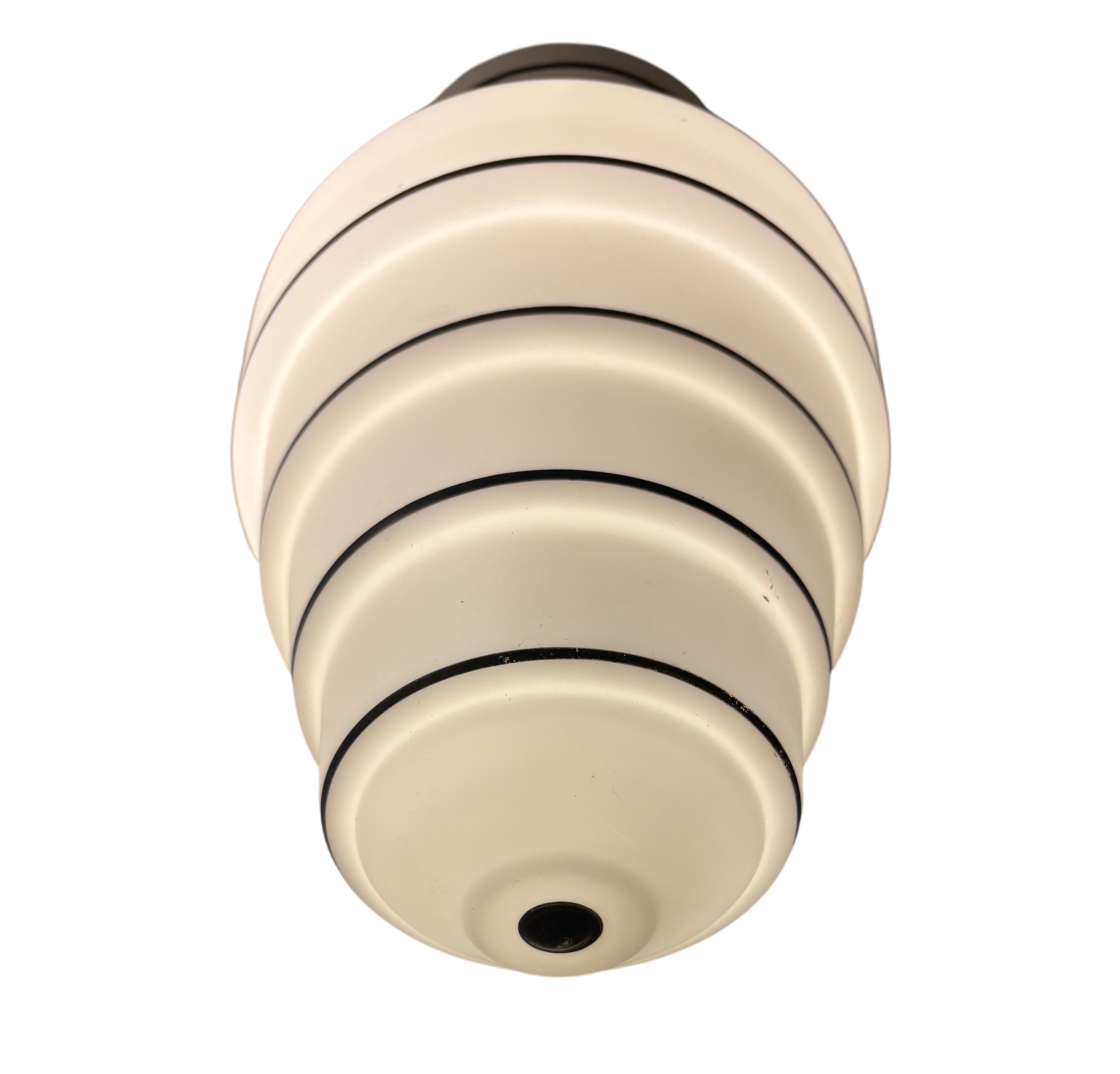 Decorative ceiling light fixture with beige and black design on a white background