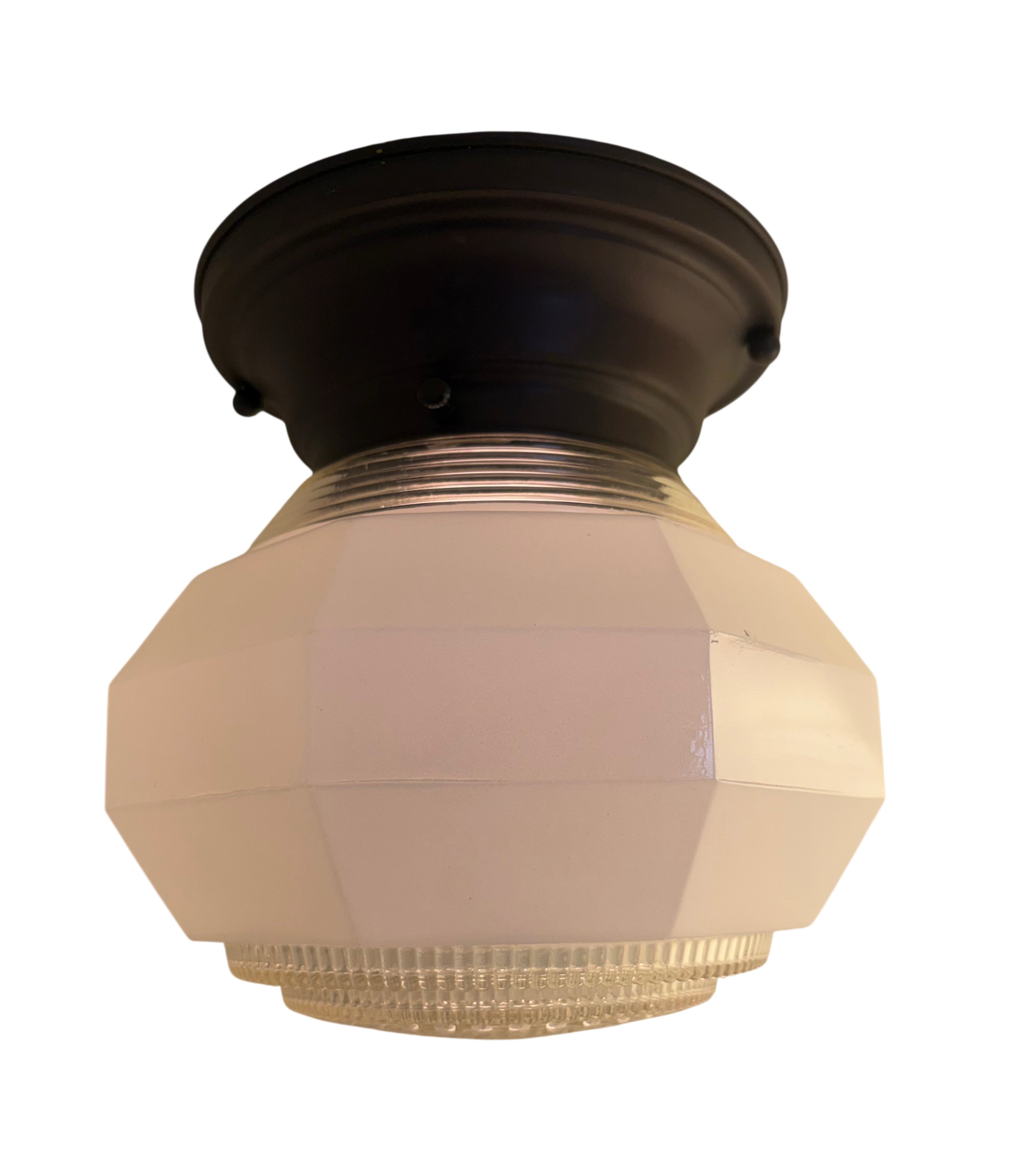 Ceiling light fixture with beige glass shade and black metal fixture on a white background
