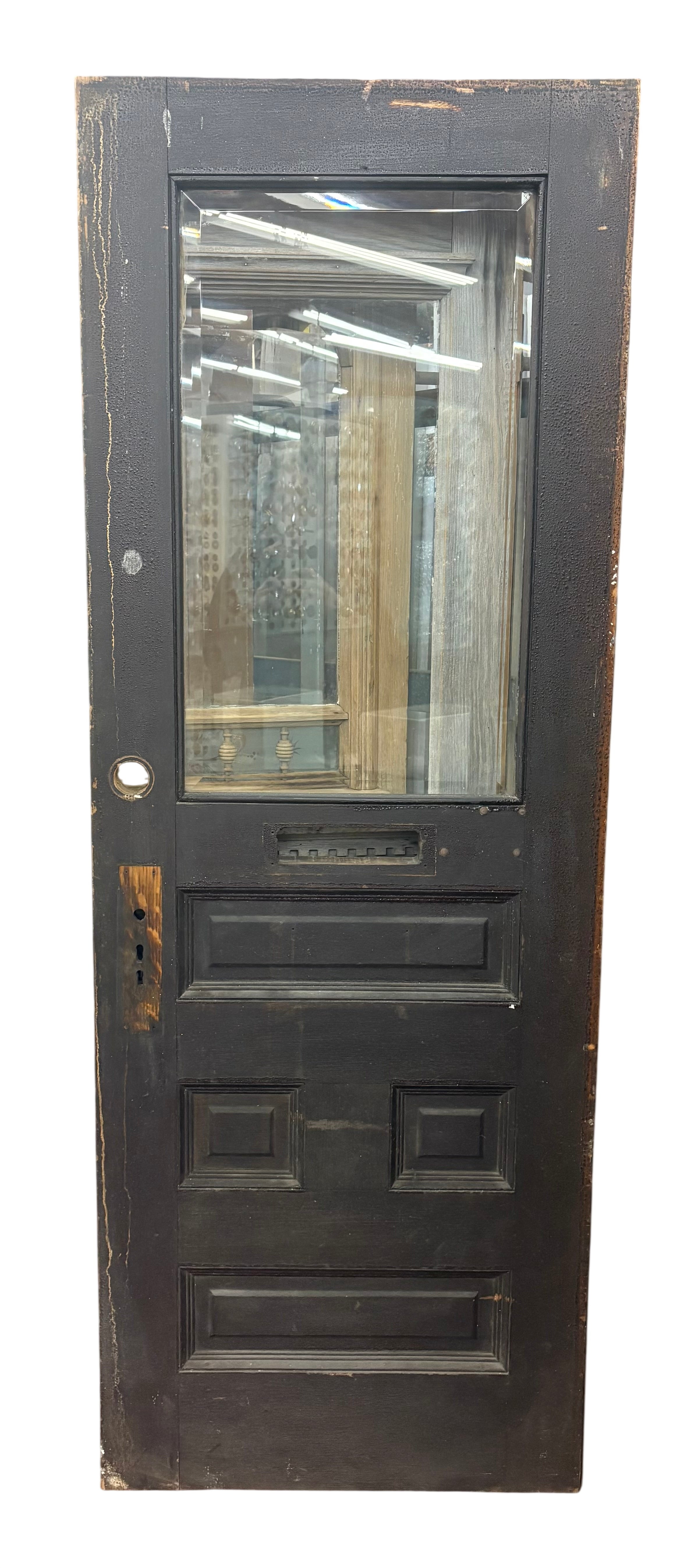 Vintage-style black door with glass panels in a warehouse setting