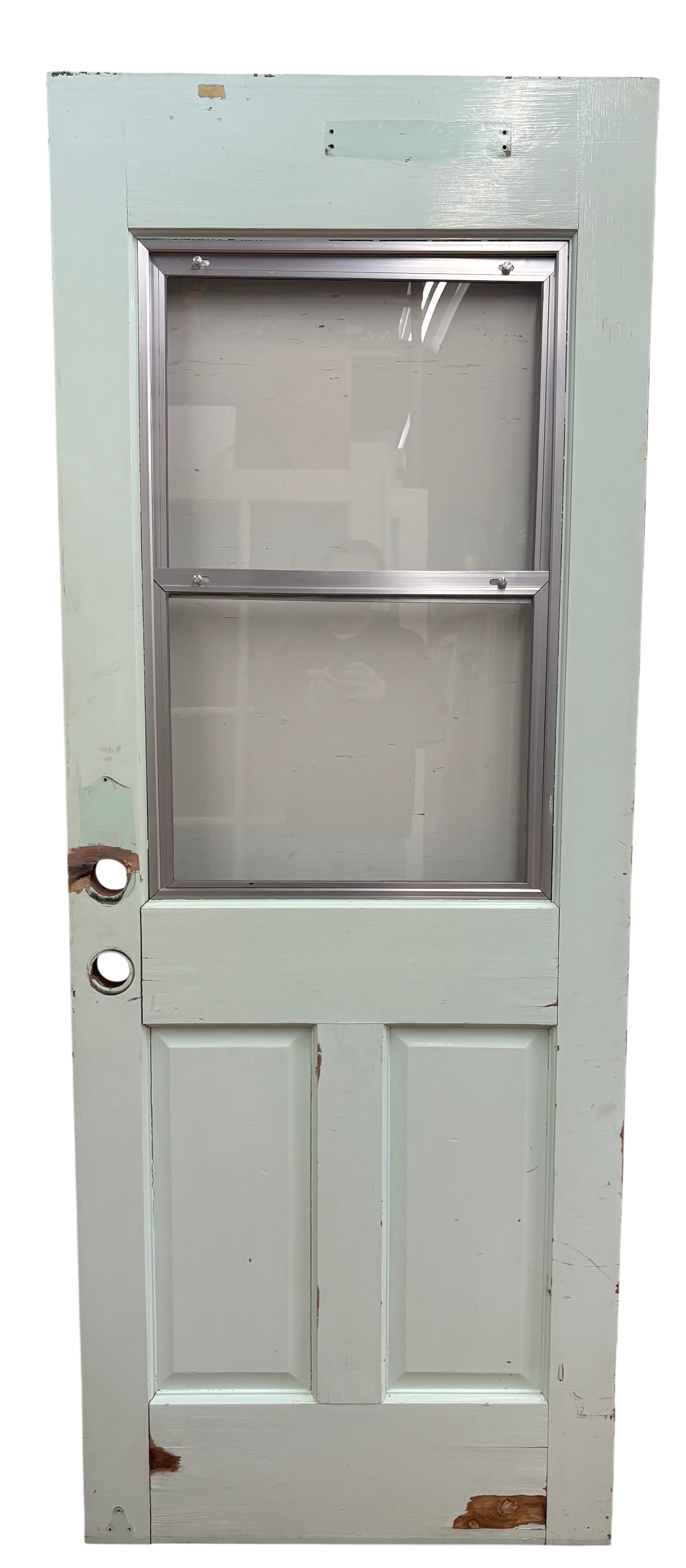 Vintage wooden door with glass panel against a light pink background