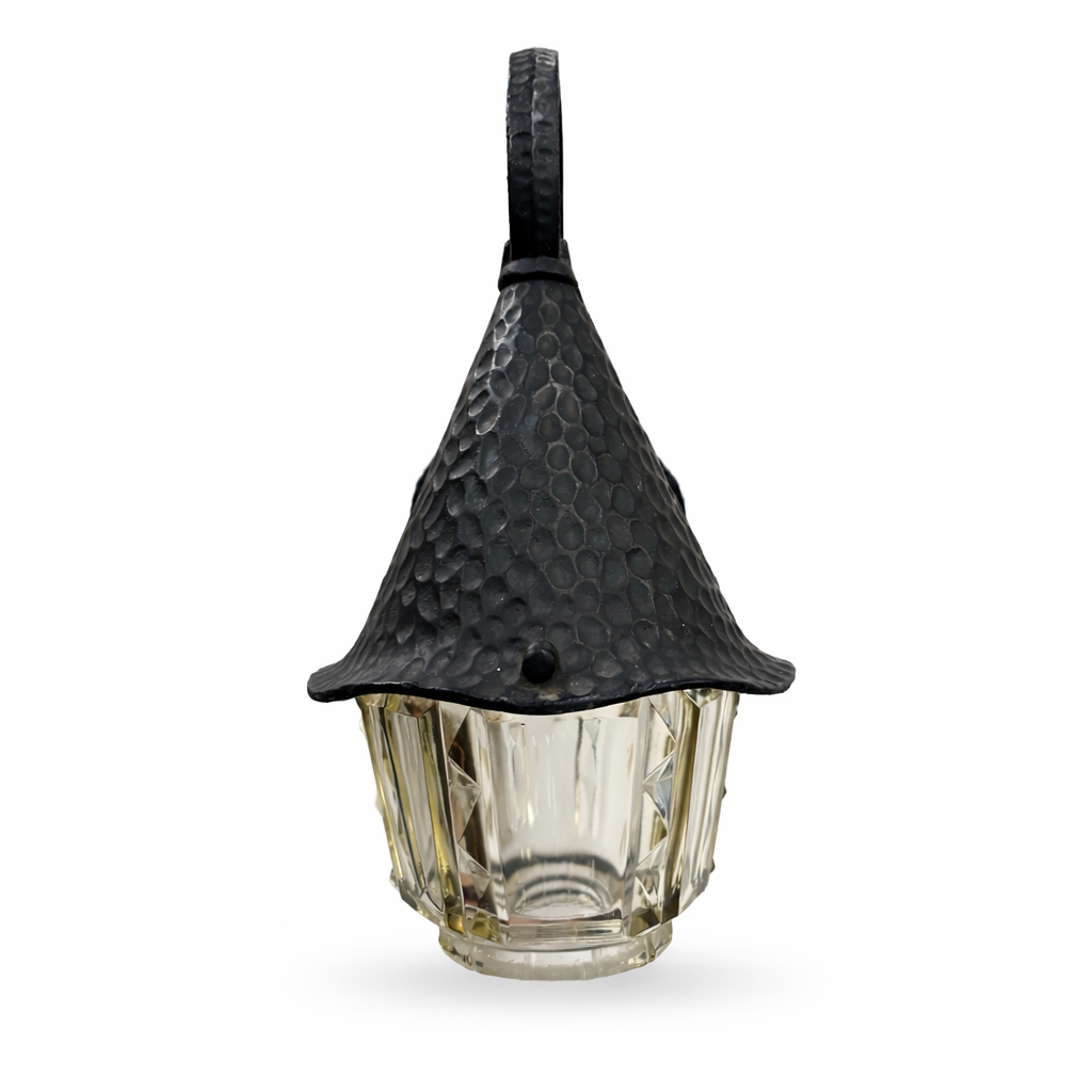 Decorative outdoor light fixture with a black metal hood and glass base on a white background