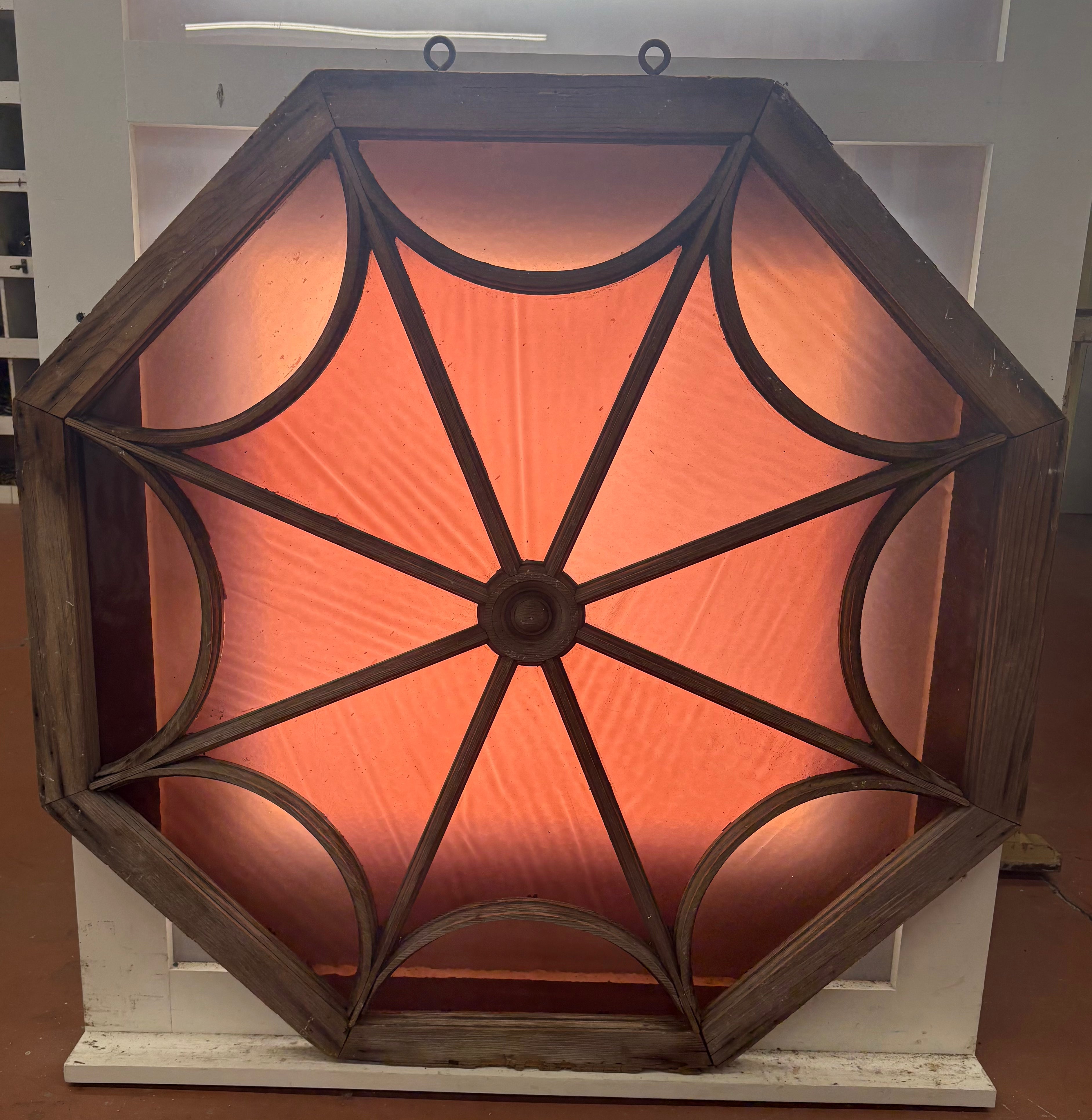 Decorative wall light with spider web design and warm glow