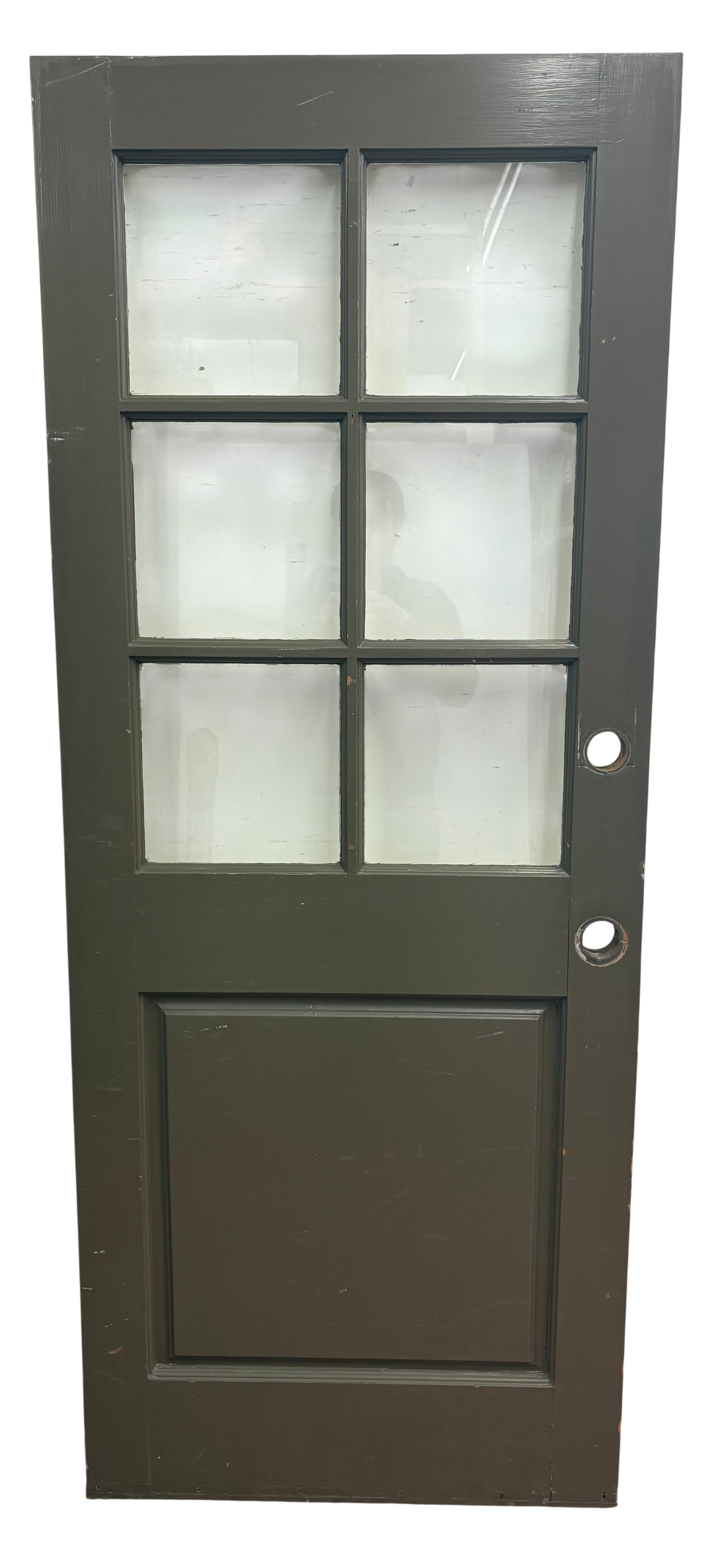 Green door with glass panels on a white wall