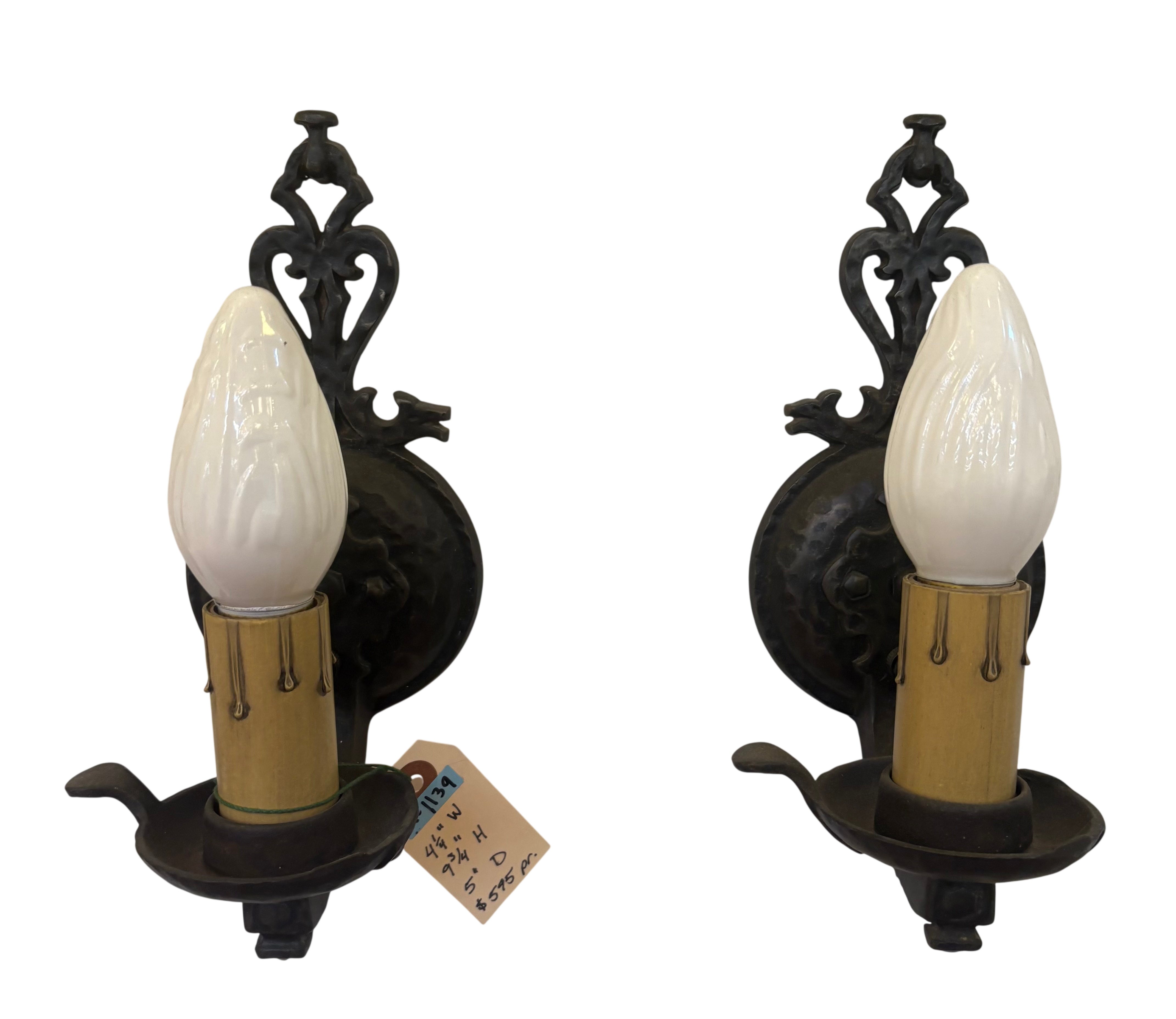 Pair of vintage-style wall sconces with black metal fixtures and white glass shades on a white background.